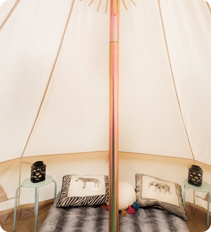 Tent with bed, pillows, and on tables